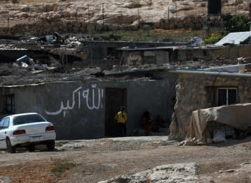 The occupation beats a civilian during the demolition of his house in Masafer Yatta