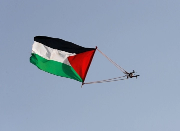 The Palestinian flag flutters in the sky of Bab al-Amud and the Old City