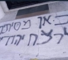 Settlers take slogans on the walls of a mosque in Deir Dabwan