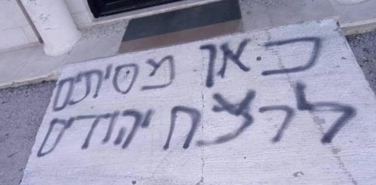 Settlers take slogans on the walls of a mosque in Deir Dabwan