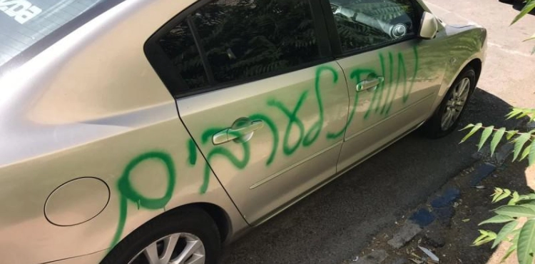 Settlers write slogans and ruin tires of 15 vehicles in Issawiya town