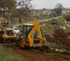 Settlers carry out dredging work in the lands of the Asira al-Qibliya
