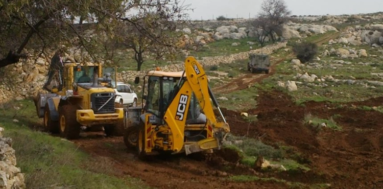 Settlers carry out dredging work in the lands of the Asira al-Qibliya