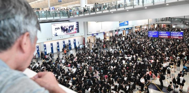 Thousands of protesters in Hong Kong sit in the airport
