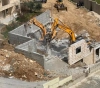 The Israeli occupation forces demolish a house in Beit Ummar village north of Hebron
