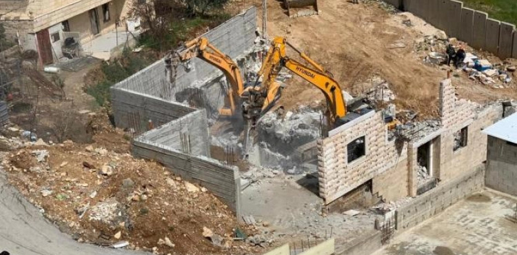 The Israeli occupation forces demolish a house in Beit Ummar village north of Hebron