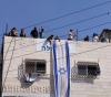 Settlers take over the roof of a house in Hebron
