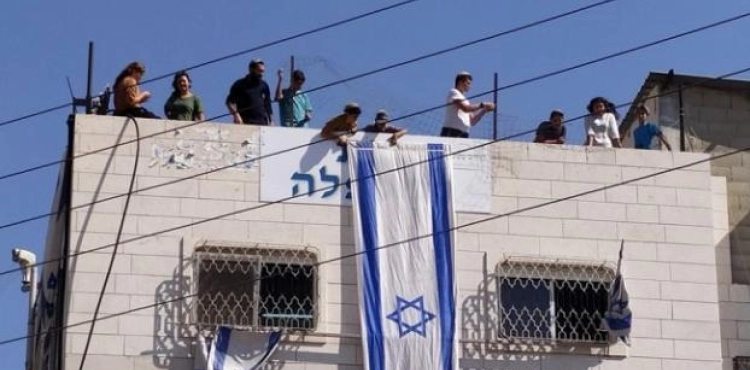 Settlers take over the roof of a house in Hebron