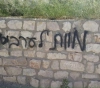 Settlers burn a vehicle and write racist slogans in Taybeh and Deir Ammar