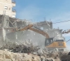 She shelters 55 people.. The occupation notifies the demolition of a building in Shuafat